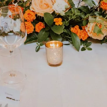 Photophore en verre métallisé doré sur table avec fleurs