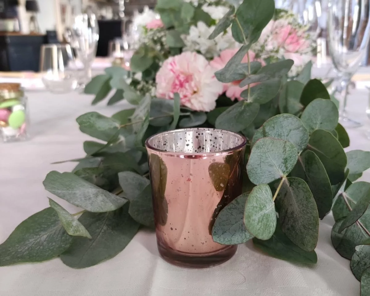Photophore en verre métallisé rose gold sur table avec fleurs